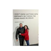 Daughter and dad standing at front of a banner 