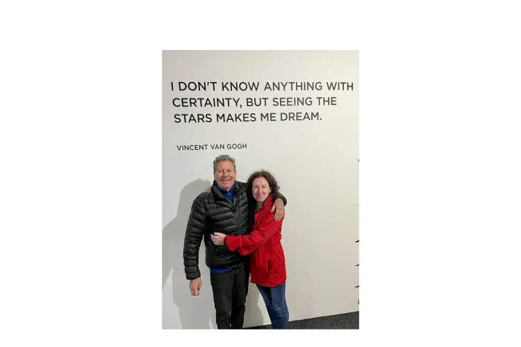 Daughter and dad standing at front of a banner 